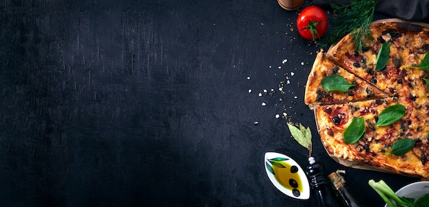 Pizza e pizza italiane che cucinano gli ingredienti su fondo scuro