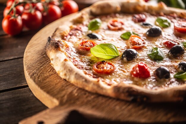 Pizza fatta in casa con pomodori, mozzarella, olive e basilico