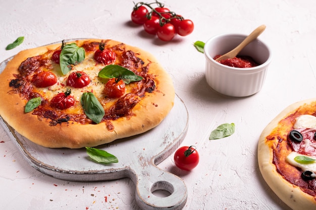 Pizza fatta in casa con pomodoro e basilico su una lavagna bianca