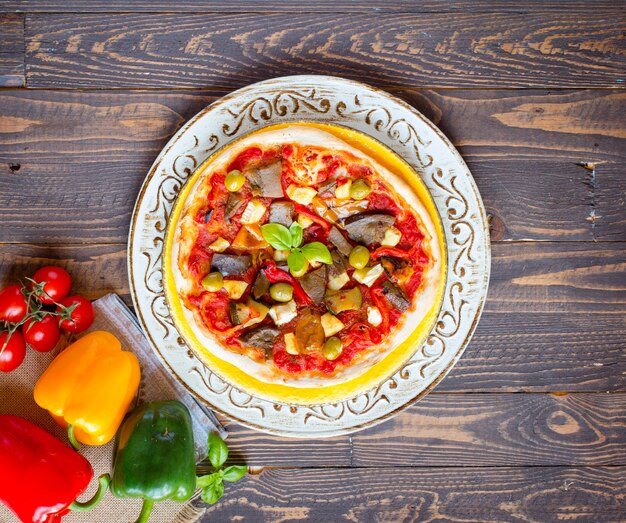 Pizza fatta in casa fresca con diverse verdure su un tavolo di legno