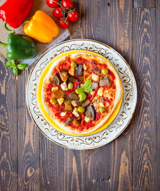 Pizza fatta in casa fresca con diverse verdure su un tavolo di legno