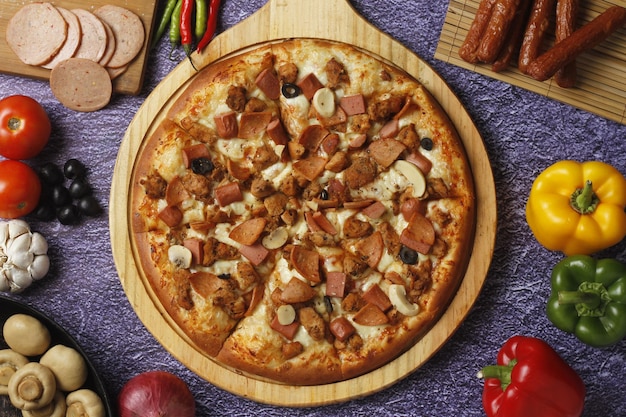 Pizza flatbread guarnita con angolo fresco su tavola per pizza in legno vista dall'alto Sfondo in pietra scura