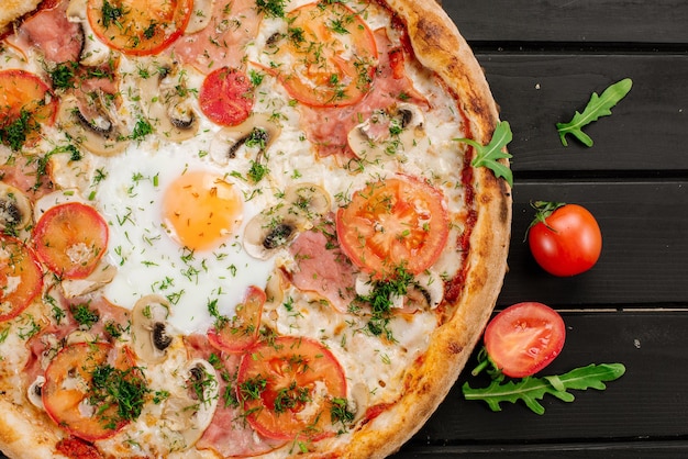 Pizza fresca alla carbonara con uova strapazzate su fondo di legno