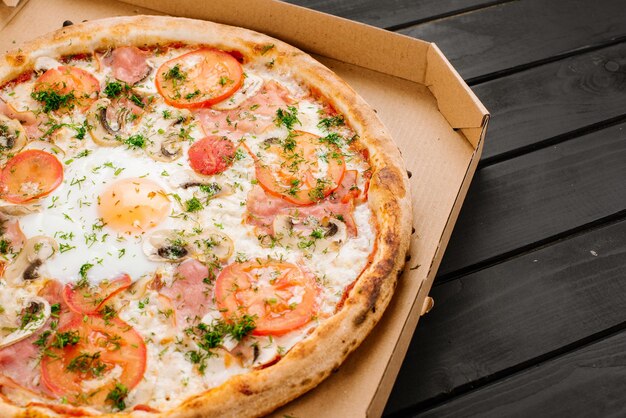 Pizza fresca alla carbonara con uova strapazzate su fondo di legno