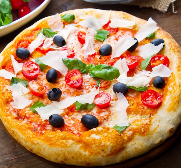 Pizza fresca deliziosa servita sulla tavola di legno