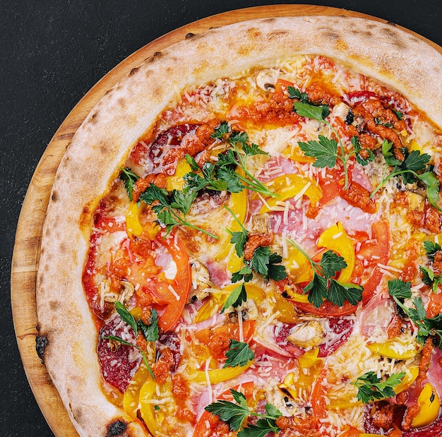 Pizza fresca e deliziosa fatta in forno a focolare con pepe di salsiccia e pomodori