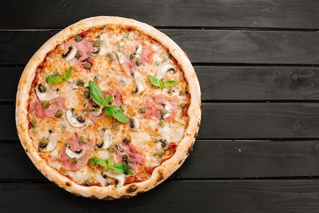 Pizza fresca gustosa con ingredienti su fondo di legno