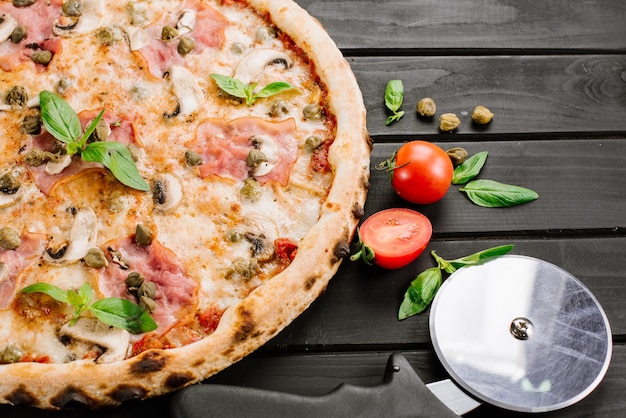 Pizza fresca gustosa con ingredienti su fondo di legno