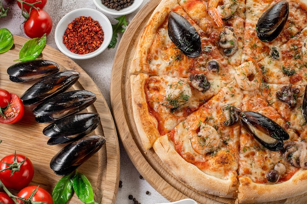 Pizza gustosa con calamari e cozze di mare sullo sfondo di cemento