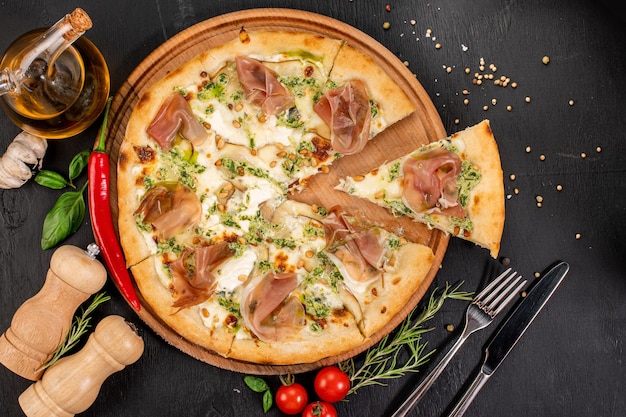 Pizza gustosa con formaggio philadelphia e prosciutto su fondo di legno