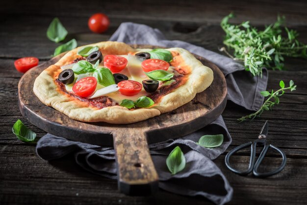 Pizza gustosa con olive formaggio ed erbe aromatiche