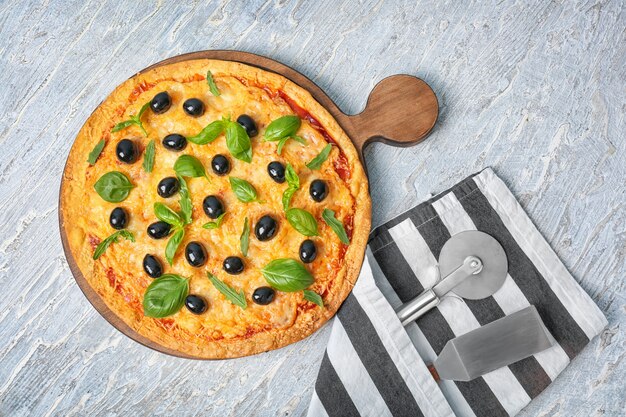 Pizza gustosa con olive in tavola