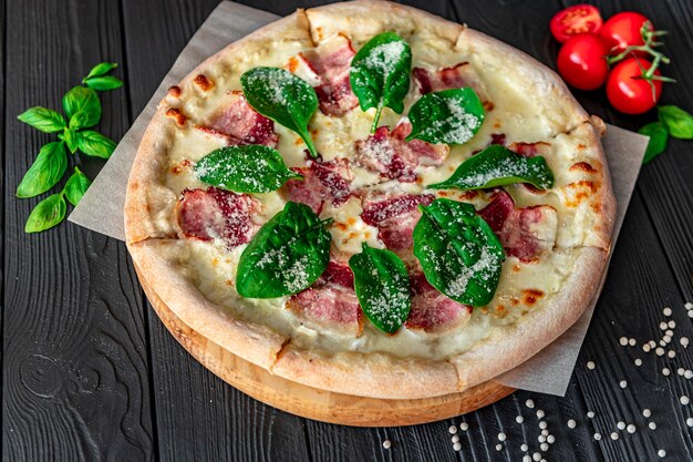 Pizza gustosa e grande con pancetta e insalata fresca