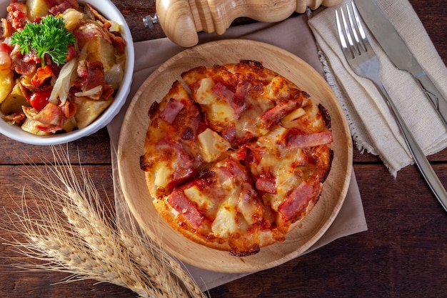 Pizza hawaiana sul piatto di legno