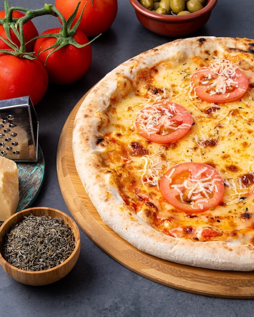 Pizza in stile napoletano su sfondo di pietra con pomodori olive e oregano