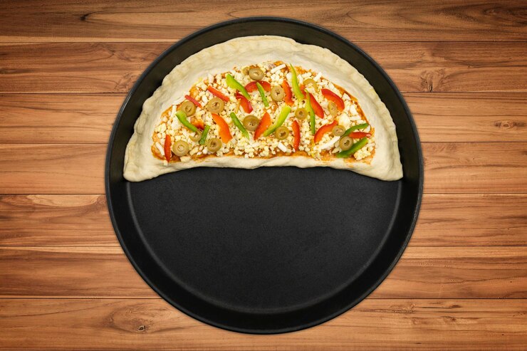 Foto pizza in una ciotola di legno su un tavolo di legno