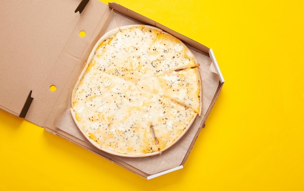 Pizza in una scatola aperta su sfondo giallo Vista dall'alto