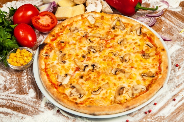Pizza italiana con diversi tipi di verdure e carne di formaggio