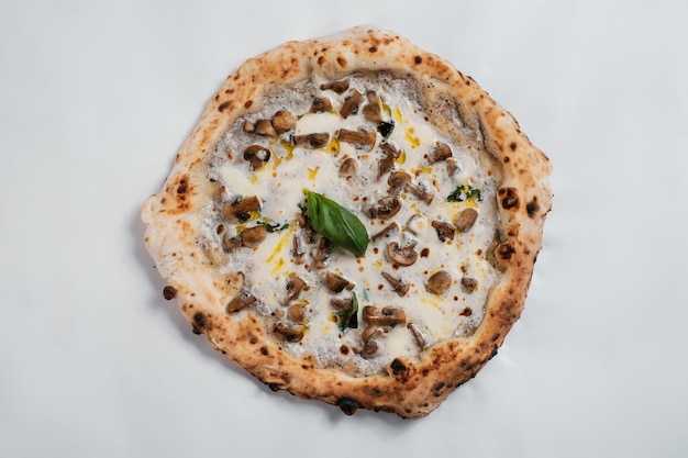 Pizza italiana con formaggio ai funghi e olio d'oliva su sfondo bianco
