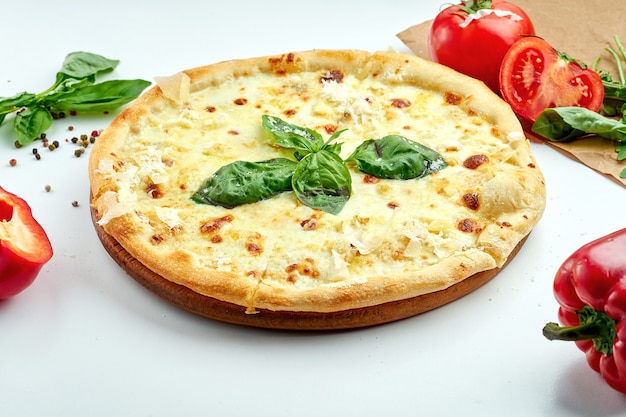 Pizza italiana con formaggio e basilico su un piatto bianco
