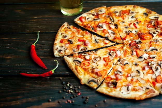 pizza italiana con funghi, pomodori e formaggio su legno