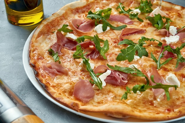 Pizza italiana con prosciutto, rucola e crema di formaggio., Cibo piatto laici