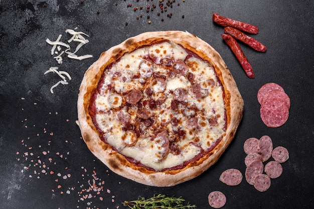 Pizza italiana deliziosa fresca con quattro tipi di carne su uno sfondo di cemento scuro. cucina italiana