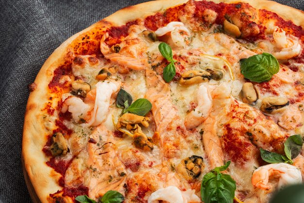 Pizza italiana di mare con gamberi, calamari, cozze, erbe fresche e mozzarella