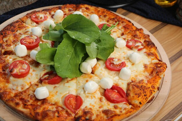 Pizza italiana fatta in casa con mozzarella, salame, salsa di pomodoro, peperoni, rucola e spezie