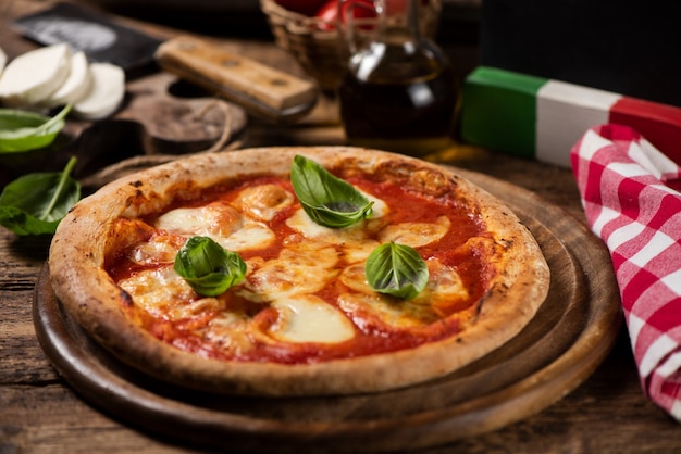 Pizza italiana Margherita su un tavolo in legno rustico. Avvicinamento