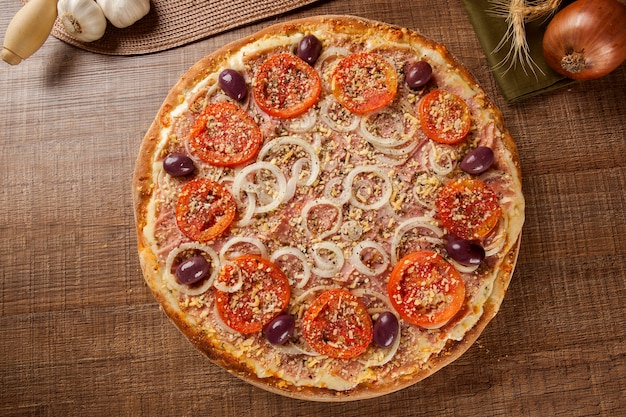 Pizza italiana tradizionale con ingredienti su legno.