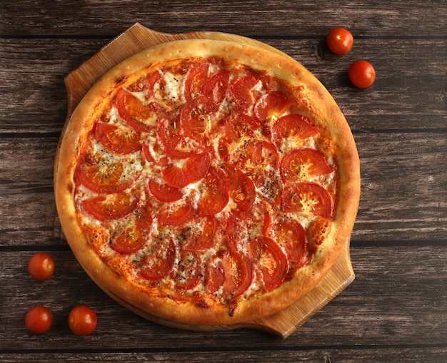 Pizza margarita con pomodori formaggio spezie su sfondo scuro