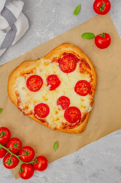 Pizza Margherita a forma di cuore con pomodori mozzarella e basilico Concetto di cibo per San Valentino