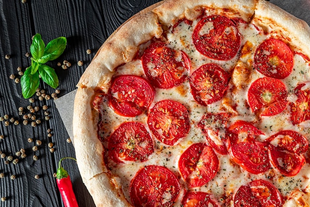 Pizza Margherita su sfondo nero vista dall'alto Pizza Margarita con Pomodori Basilico e Mozzarella