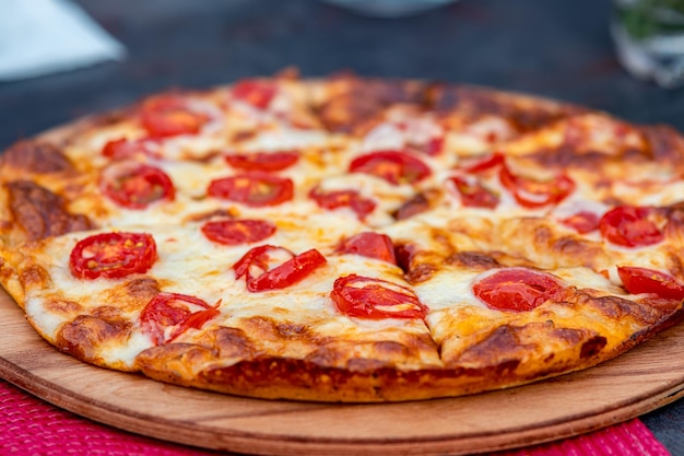 Pizza margherita su un piatto di legno da vicino