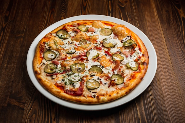 Pizza nutriente del bacon, del fungo e dei sottaceti con salsa di panna acida, fondo di legno, scuro