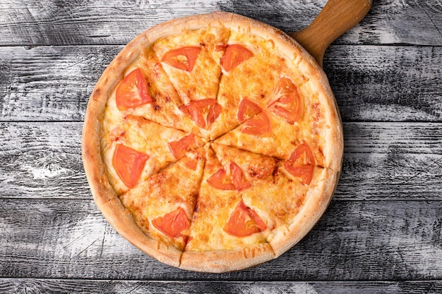 Pizza pizza calda su uno sfondo di legno bianco laterale e vista dall'alto