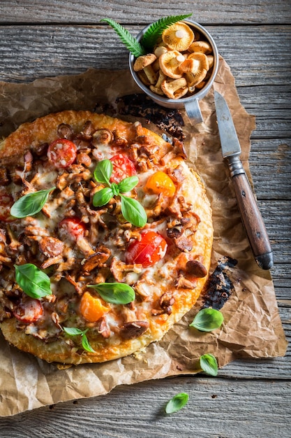 Pizza pronta da mangiare sul vecchio tavolo rustico in legno