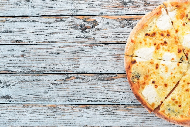 PIZZA QUATTRO FORMAGGI Cucina italiana Su fondo in legno Spazio libero per testo Vista dall'alto