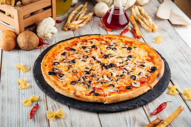 Pizza quattro stagioni con funghi olive e pomodoro