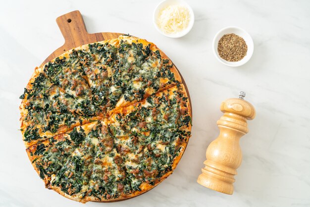 pizza spinaci e formaggio su vassoio di legno - stile vegano e vegetariano