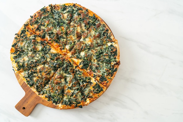 pizza spinaci e formaggio su vassoio di legno - stile vegano e vegetariano