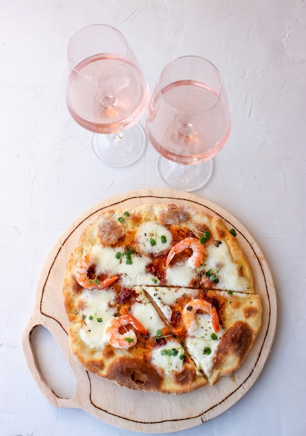 Pizza su una tavola di legno con mozzarella, mini rucola.