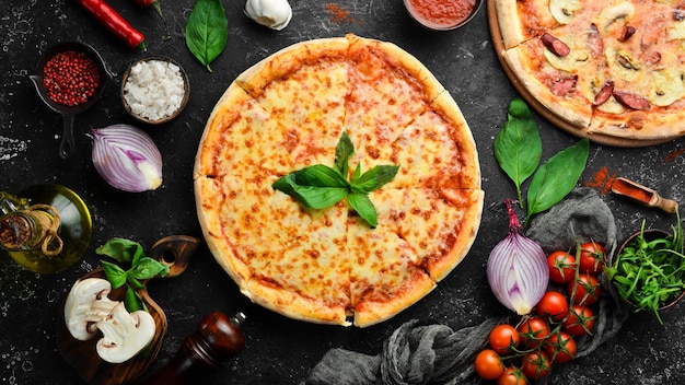 Pizza tradizionale con formaggio e salsa di pomodoro su sfondo di pietra nera Spazio libero per il testo