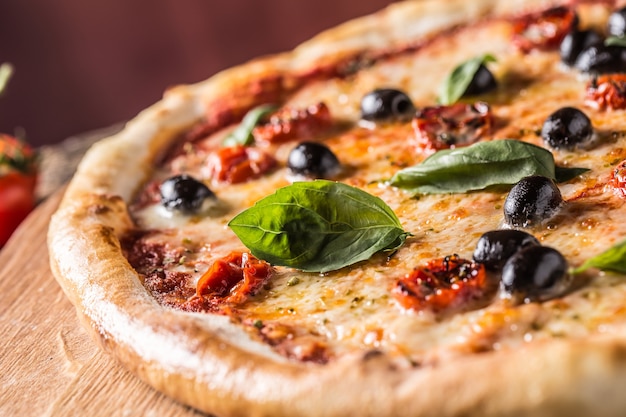 Pizza. Una gustosa pizza italiana fresca servita su un vecchio tavolo di legno.