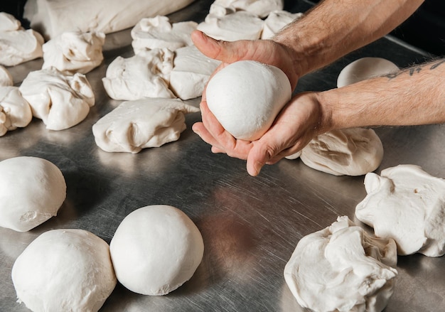 Pizzaiolo e palline di impasto per la cotturax9xA