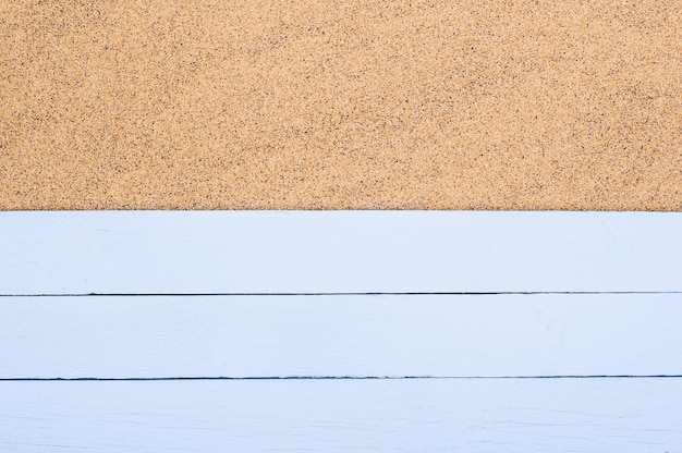 Plance di legno blu sulla sabbia, spazio della copia