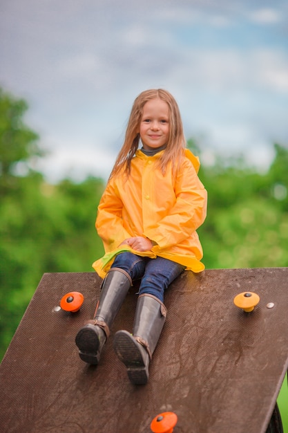 Playng felice della bambina sul campo da giuoco all'aperto