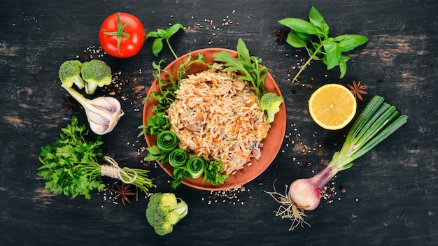 Plov Riso con carne e verdure su un piatto Cucina uzbeka su sfondo di legno Vista dall'alto Spazio di copia