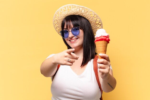 Plus size bella donna con occhiali da sole, gelato e un cappello in vacanza